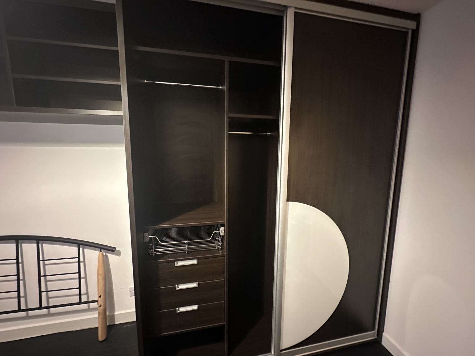 Inside the Bedroom 1 fitted wardrobes, showing hanging rails, shelves, drawers and a wire basket