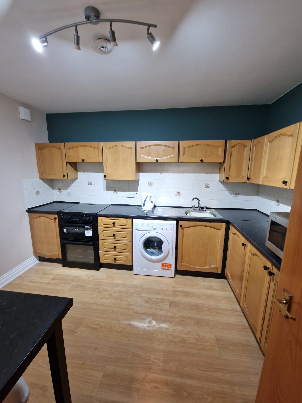 Kitchen showing the cooker, washing machine, cabinets, sink and worktops
